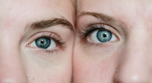Close up of two young women with blue eyes.