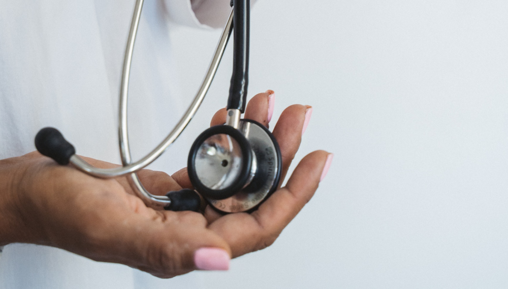 Hand holding black and silver stethoscope